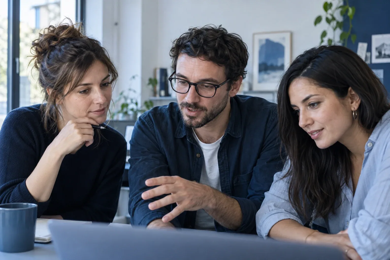 סצנה שנוצרה ב־AI: שלושה מומחי שיווק דנים בעבודה סביב מחשב נייד במשרד.